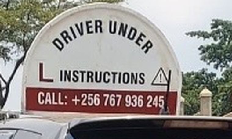 Driver under instruction roof sign on a Limtai vehicle